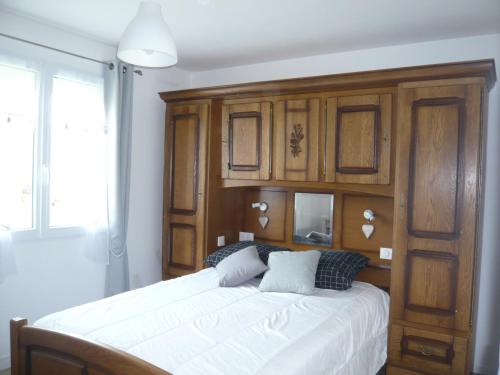 ein Schlafzimmer mit einem großen Bett mit Holzschränken in der Unterkunft Gite de la Vallée de Mai in Audignicourt