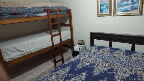 - une chambre avec deux lits superposés et un lit dans l'établissement Paraíso Beira Mar, Casa Temporada Itanhaém, 30m Praia, Vista Mar, Piscina, Hidro, Wi-Fi 500 mb, Snooker, Churrasqueira, Garagem Grande, Lazer e Descanso, à Itanhaém