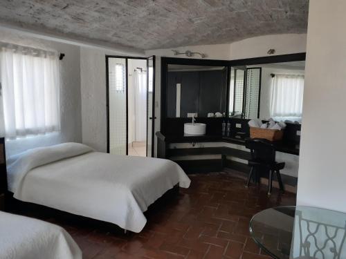 a bedroom with a bed and a desk in it at Casa Blanca San Miguel in San Miguel de Allende