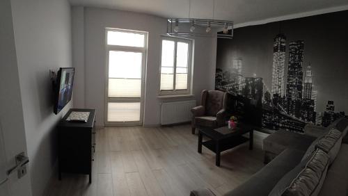 ein Wohnzimmer mit einem Sofa und einem Tisch in der Unterkunft Apartamenty przy zamku in Pasłęk