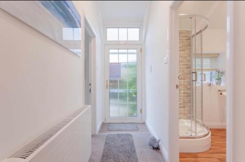 a hallway with a bathroom with a shower and a door at Lundy Lookout 5 minutes drive to beach Hot tub in Westward Ho