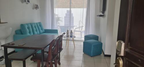 a living room with a table and a blue couch at Casa Vacacional en Herradura con piscina privada in Herradura