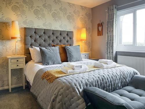 een slaapkamer met een groot bed en handdoeken bij Gretna - Uk41823 in Longnor
