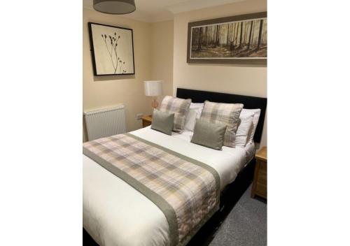 a bedroom with a bed with pillows at The Waverley Inn Holiday Homes in Inverness