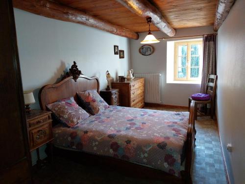 une chambre avec un lit, une commode et une fenêtre dans l'établissement CHARMANTE MAISON A LA CAMPAGNE AU COEUR DES PREMIERS VOLCANS, à Mézères