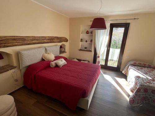 a bedroom with a red bed with two stuffed animals on it at B&B La Dolce Sosta in Fonni