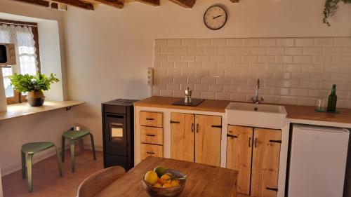 a kitchen with a table and a clock on the wall at El rinconin del Sueve in San Martín