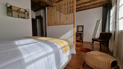 ein Schlafzimmer mit einem Bett und einem Stuhl in einem Zimmer in der Unterkunft El rinconin del Sueve in San Martín