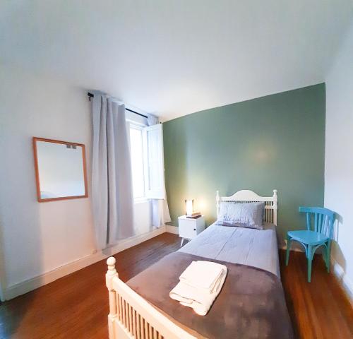 1 dormitorio con 1 cama blanca y 1 silla azul en LOPEZ Hostel & Suites en Buenos Aires