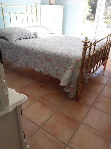 une chambre avec un lit avec un couvre-lit fleuri dans l'établissement Villa Marie & Pierre, à La Verdière