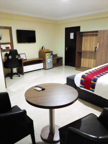 ein Hotelzimmer mit einem Bett und einem Couchtisch in der Unterkunft RHOGEM Hotel in Takoradi