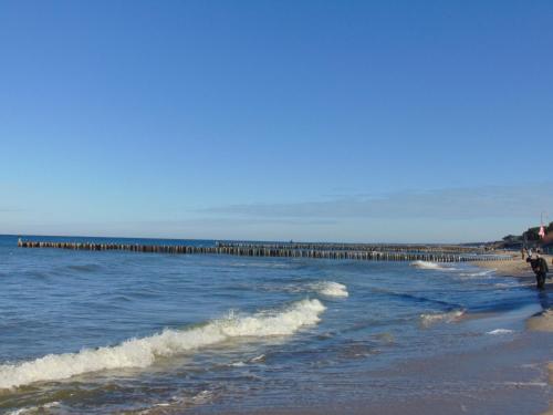 a beach with a pier in the water at Apartament Planeta 110 Mielno in Mielno