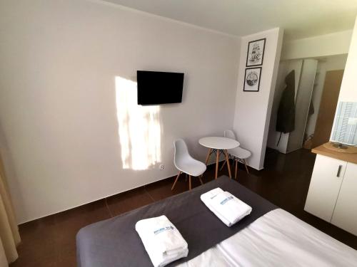 a bedroom with a bed and a table and a tv at Apartament Planeta 110 Mielno in Mielno