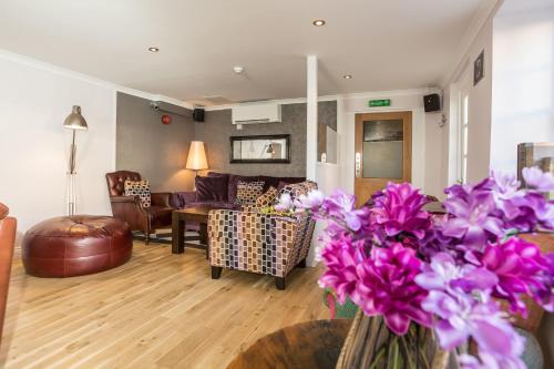a living room with purple flowers in a vase at Duke Of Normandie in St Peter Port