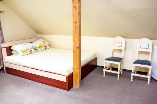 1 Schlafzimmer mit einem Etagenbett und 2 Stühlen in der Unterkunft Mingės Egzotika in Mingė