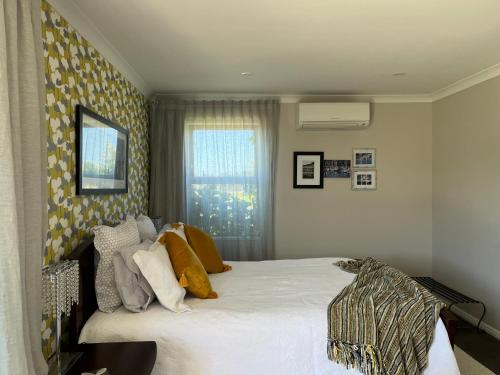 a bedroom with a large white bed and a window at Ra-ata Farm in Rangiora