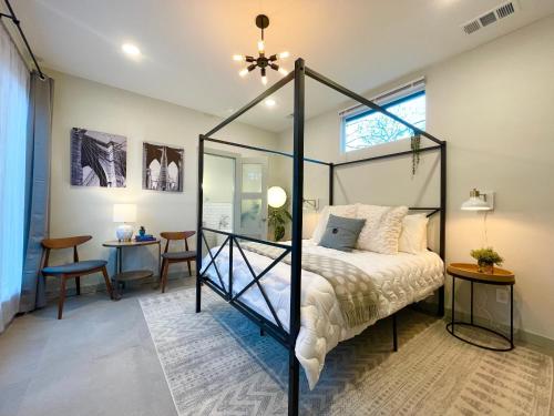 a bedroom with a canopy bed and a desk at Downtown Views, Rooftop Deck, Pets in Dallas