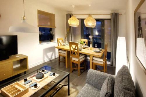 een woonkamer met een bank en een eetkamer bij Japanese Style MUJI Two-Bedroom Apt in Swansea
