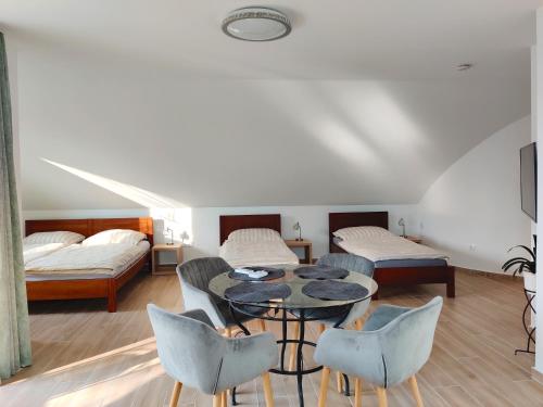 Zimmer mit einem Tisch, Stühlen und einem Bett in der Unterkunft Dali Apartment Szentendre in Szentendre