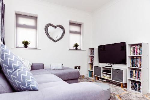 a living room with a couch and a tv at Willow Chalet near Cartmel & Lake Windermere in Flookburgh