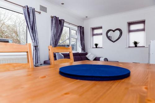 a living room with a blue circle on a wooden table at Willow Chalet near Cartmel & Lake Windermere in Flookburgh