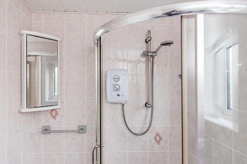 a bathroom with a shower with a glass door at Willow Chalet near Cartmel & Lake Windermere in Flookburgh