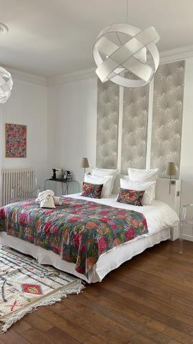 a bedroom with a large bed and a chandelier at Maison Douce Arles in Arles