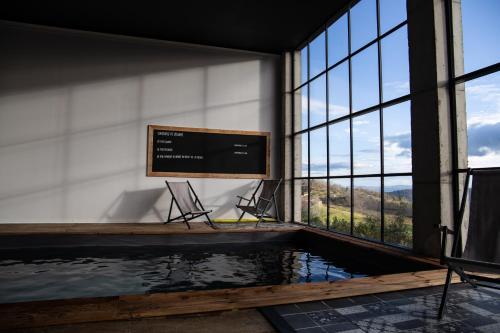 a room with a pool of water and a large window at Un petit bout du monde in Saint-Georges-en-Couzan