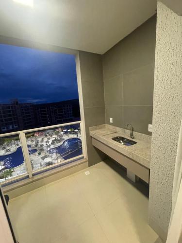 a bathroom with a sink and a large window at Lagoa EcoTowers Resort Hotel in Caldas Novas