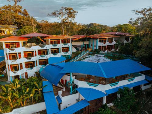 an aerial view of a resort with blue roofs at Hotel Planeta Sano in Manuel Antonio