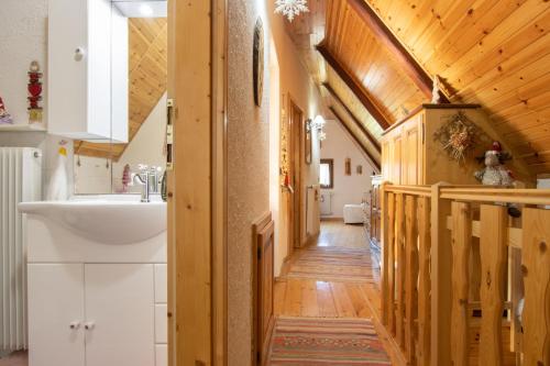 un pasillo en una casa con lavabo y techos de madera en CASA VACANZA "AI PIEDI DEL BOSCO", en Malborghetto Valbruna