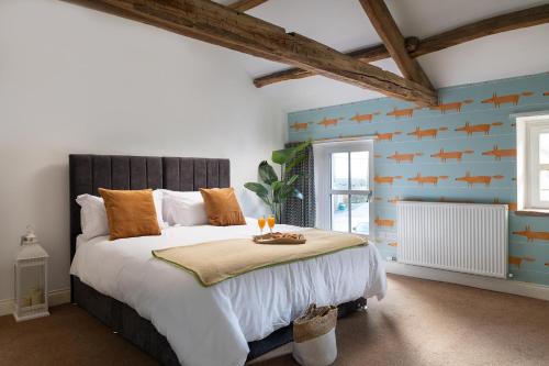 a bedroom with a large bed with orange pillows at Brow Top Cottage, Penrith, Lake District in Skelton