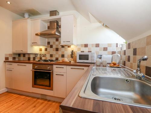 a kitchen with a sink and a microwave at Harbour Reach 6 in Weymouth