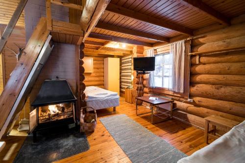 a living room with a fireplace in a log cabin at Peurasuvanto Mökit & Camping in Peurasuvanto
