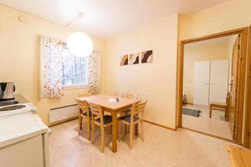 a kitchen and dining room with a table and chairs at Peurasuvanto Mökit & Camping in Peurasuvanto