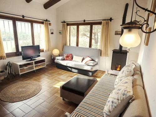 a living room with a couch and a tv at Belvilla by OYO La Barraca in Palafrugell