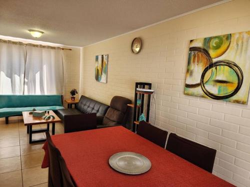 uma sala de estar com uma mesa vermelha e um sofá em Casa a pocos minutos de playa La Herradura em Coquimbo