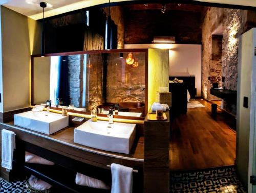 a bathroom with two sinks and a large mirror at Hotel Boutique Rayón 50 in Morelia