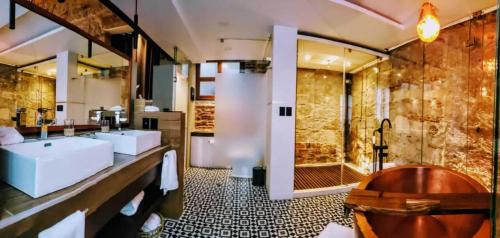 a bathroom with a tub and three sinks and a shower at Hotel Boutique Rayón 50 in Morelia