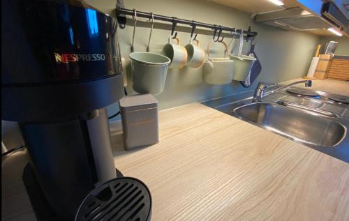 a kitchen with a coffee pot and a sink at Leilighet sentralt til Sandefjord og Torp flyplass in Sandefjord