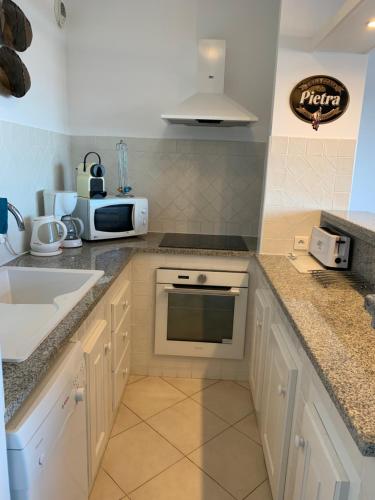 a kitchen with a sink and a counter top at T2 clim 54m2, 17m2 de terrasse très belle vue mer in LʼÎle-Rousse