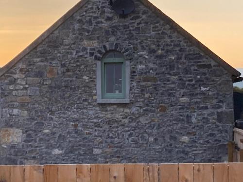 a window on the side of a stone building at Knockreagh Farm Cottages Mountain or Cedar views in Kilkenny