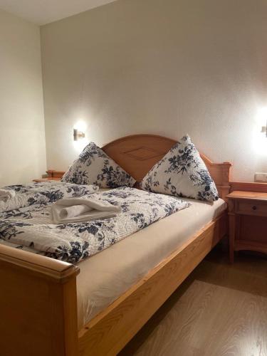 a bed with blue and white sheets and pillows at Hotel und Restaurant Grüner Hahn in Elsenfeld