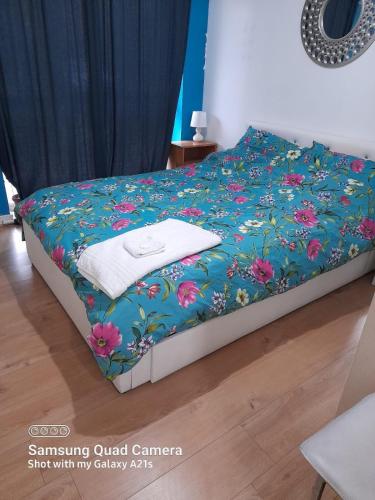 - un lit avec une couverture bleue et des fleurs dans l'établissement Beautiful 1 bedroom Ground floor with shared bathroom, à Londres