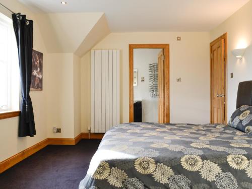 a bedroom with a bed and a window at Drummygar Mains in Carmyllie