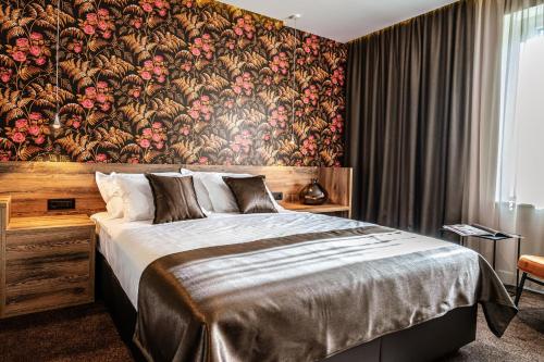 a bedroom with a large bed with a floral wallpaper at Calma Luxury Rooms in Split