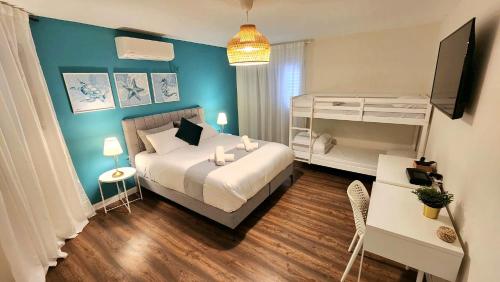 um quarto com uma cama branca e uma parede azul em VILLA SHUNIT- וילה שונית by barak royal suites em Eilat