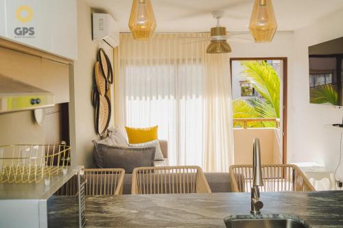 a kitchen and living room with a table and chairs at Con alberca a 5 minutos de la playa by G P S rentas in Mazatlán