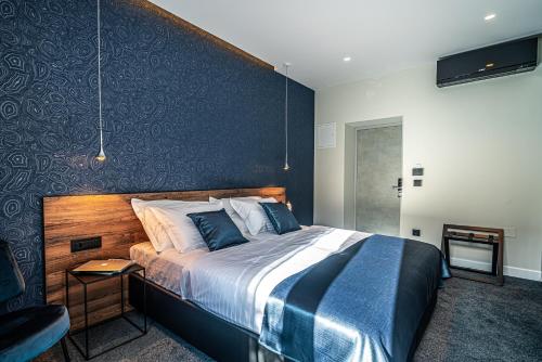 a bedroom with a large bed and a chair at Calma Luxury Rooms in Split