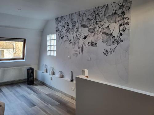 a room with a wall with a painting of butterflies at Nuitées / télétravail in Dunkerque